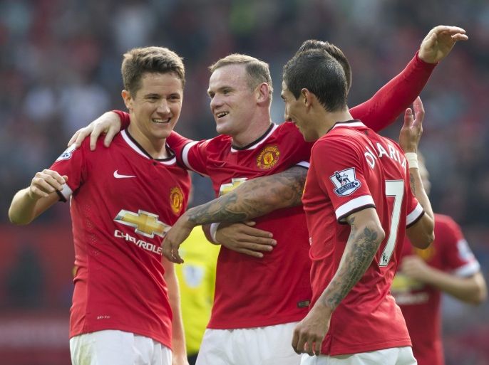 Manchester United's Wayne Rooney, centre, celebrates with teammates after scoring against Queens Park Rangers during their English Premier League soccer match at Old Trafford Stadium, Manchester, England, Sunday Sept. 14, 2014. (AP Photo/Jon Super)