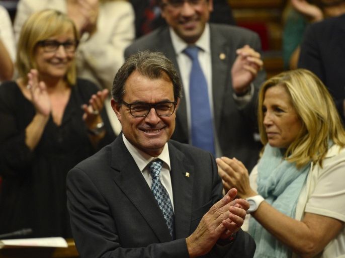 Catalonia's regional president Artur Mas, centre, celebrates after the Catalan Parliament approved the Law allowing Catalonia's Government to call on a self-determination referendum from Spain at the Parliament of Barcelona, Spain, Friday, Sept. 19, 2014. A day after Scotland rejected breaking away from Britain, the regional parliament in Spain's Catalonia is expected to grant its leader the power to call a secession referendum that the central government in Madrid says would be illegal. (AP Photo/Manu Fernandez)