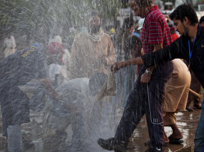 Pakistani protesters wash their eyes after being hit by tear gas outside the parliament building in Islamabad, Pakistan, Sunday, Aug. 31, 2014. Thousands of anti-government protesters tried to raid the official residence of Prime Minister Nawaz Sharif, sparking clashes with police that killed a few people and wounded hundreds amid cries for the premier to step down, officials said Sunday. (AP Photo/B.K. Bangash)