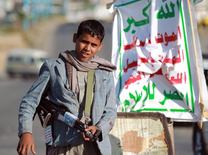 An armed Yemeni Shiite Huthi child rebel masn a checkpoint erected in the capital Sanaa on September 23, 2014. Yemeni President Abdrabuh Mansur Hadi vowed to restore state authority and warned of 'civil war' in the Sunni-majority country as Shiite rebels were seen in near-total control of the capital. AFP PHOTO / MOHAMMED HUWAIS
