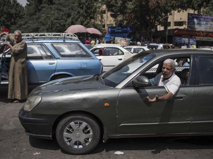 A man, right, talks to another driver as they wait in line for fuel at a gas station, one of the businesses affected by a power outage in Giza, Cairo's neighboring city, Egypt, Thursday, Sept. 4 2014. The man said he's been in line since six in the morning. He was there for three hours. Egypt suffered a massive power outage that halted parts of the Cairo subway, took TV stations off the air and ground much of the country to a halt for several hours Thursday, as officials offered no clear explanation for how the country suddenly lost 50 percent of its power generation. (AP Photo/Eman Helal)