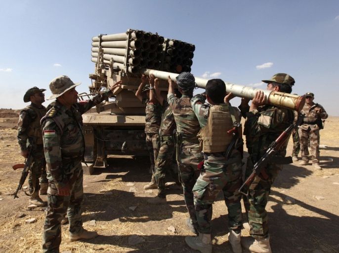 Iraqi Kurdish peshmerga troops load rockets into a launcher during fighting with Islamic State militants in Khazir, September 16, 2014. REUTERS/Azad Lashkari (IRAQ - Tags: CIVIL UNREST POLITICS CONFLICT MILITARY)
