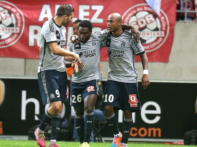 Marseille teammates celebrate after Marseille's Ghanaian forward Andre Ayew (C) scored a goal on September 23, 2014 during a French L1 football match between Reims and Marseille at the Auguste Delaune stadium in Reims. AFP PHOTO / FRANCOIS NASCIMBENI