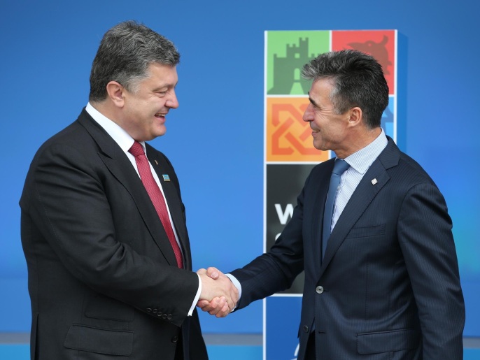 الرئيس الأوكراني بوروشينكو (يسار) يصافح الأمين العام للناتو راسموسن (غيتي إيميجز)