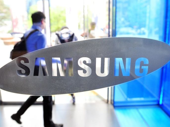 A visitor walks past a logo of Samsung Electronics at the company's headquarters in Seoul on April 29, 2014. Samsung Electronics reported on April 29 its net profit had risen 5.9 percent year-on-year in the first quarter to 7.57 trillion won (USD 7.3 billion) but operating profit declined for a second straight quarter on slowing smartphone revenue. AFP PHOTO / JUNG YEON-JE