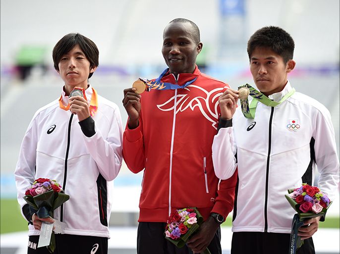 L-R) Silver medallist Japan's Kohei Matsumura, gold medallist Bahrain's Mahboob Ali Hasan Mahboob and bronze medallist Japan's Yuki Kawauchi pose with their medals on the podium during the victory ceremony for the men's