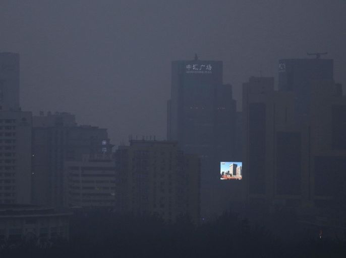 A large LCD screen showing a view of blue skies and buildings is seen amidst the smog clad city of Beijing, China, 25 September 2014. Vows to tackle climate change, commitments to meet emission reduction targets and promises of financial assistance were thick on the ground on 23 September when world leaders were meeting for the UN Climate Summit. China's Vice Premier Zhang Gaoli pledged that China will provide financial help to developing countries to tackle climate change and will give 6 million dollars to a fund set up by Ban to assist developing nations.