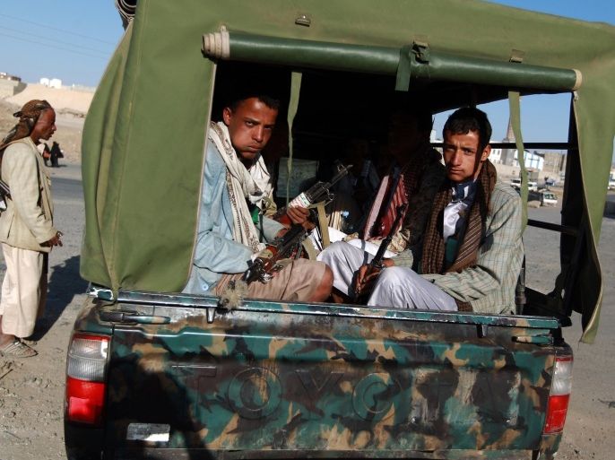 Armed Yemeni Shiite Huthi rebels sit in the back of a truck next to a checkpoint erected in the capital Sanaa on September 23, 2014. Yemeni President Abdrabuh Mansur Hadi vowed to restore state authority and warned of 'civil war' in the Sunni-majority country as Shiite rebels were seen in near-total control of the capital. AFP PHOTO / MOHAMMED HUWAIS