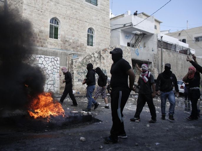 Masked Palestinian youths clash with Israeli security forces in the mostly Arab east Jerusalem neighbourhood of Abu Tor on October 30, 2014. Israeli police today shot dead a Palestinian suspected of an assassination attempt on a hardline campaigner for Jewish prayer rights at Jerusalem's flashpoint Al-Aqsa mosque compound. The attack sent tensions in the city soaring to a new high, following months of almost daily clashes between Palestinians and Israeli police in Jerusalem's occupied eastern sector. AFP PHOTO/ AHMAD GHARABLI
