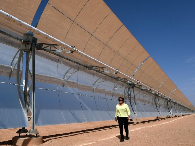 Morocco's enviornment minister, Hakima El Haite, walks infront of a solar array that is part of the Noor 1 solar power project in Ouarzazate on October 19, 2014. Morocco's first solar energy plant will begin operating in 2015, an official said, as part of a multi-billion-euro project the oil-scarce kingdom hopes will satisfy its growing energy needs. The Nour 1 plant cost 600 million euros (USD 765 million) and is expected to have a capacity to generate 160 MW. AFP PHOTO/ FADEL SENNA