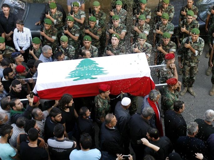Lebanese army soldiers carry the casket of their comrade Mohammad Yasin, who was killed during clashes with Islamist gunmen in the northern city of Tripoli, during his funeral in the southern Lebanese village of Kfar Tibnit, near the city of Nabatiyeh, on October 26, 2014. Lebanese troops fought a fierce and deadly battle with Islamist gunmen in the historic market of second city Tripoli, in clashes that devastated parts of the popular tourist site. AFP PHOTO/MAHMOUD ZAYYAT