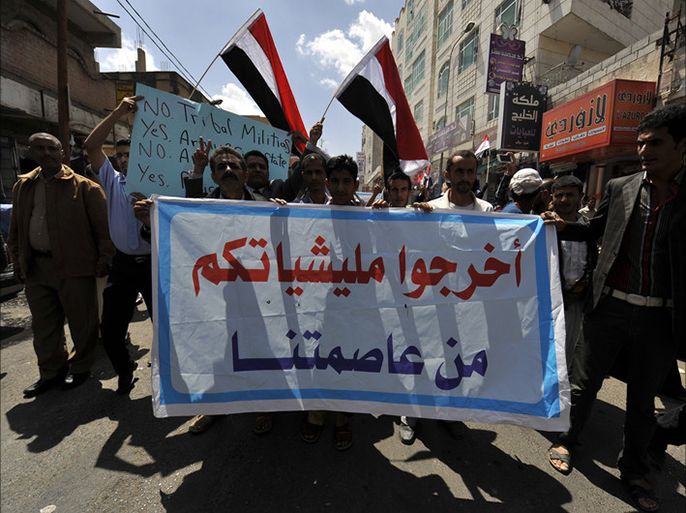 epa04424954 Yemeni activists wave Yemeni flags and hold a banner reading in Arabic ‘Take your militia away from our capital’ during an anti-Houthi militias rally in Sana'a, Yemen, 30 September 2014.