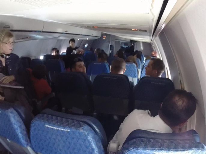 In this Monday, Oct. 13, 2014 image from video provided by passenger James Wilson of Kyle, Texas, an American Airlines Flight 2293 crew member checks a Boeing 757 cabin's wall panels that cracked loose in the interior of the plane during flight from San Francisco to Dallas. The AA Flight 2293 landed at San Francisco airport without incident about 2:15 p.m. Monday No one on the plane with 184 passengers and six crew members was hurt. While it is disconcerting for passengers to see any piece of an aircraft break, the cabin's wall panels are not part of the plane's structure, said Robert Ditchey, an aeronautical engineer with four decades of experience.(AP Photo/Courtesy of James Wilson) MANDATORY CREDIT