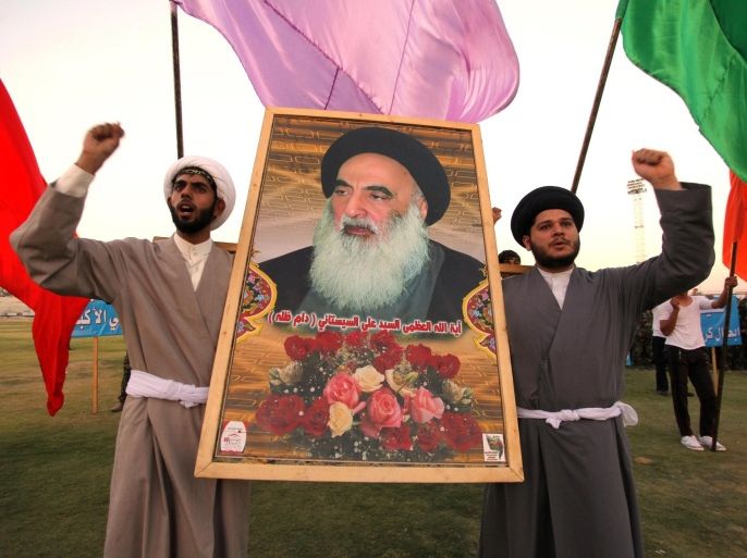 Shi'ite volunteers, who have joined the Iraqi army to fight against militants of the Islamic State, formerly known as the Islamic State in Iraq and the Levant (ISIL), carry a picture of Grand Ayatollah Ali Sistani during a graduation ceremony after completing their field training in Najaf, August 16, 2014. School is out, but northern Baghdad's classrooms are packed - not with students, but with people who have travelled further than most to escape the Sunni militant onslaught splitting Iraq. REUTERS/Alaa Al-Marjani (IRAQ - Tags: CIVIL UNREST POLITICS MILITARY)