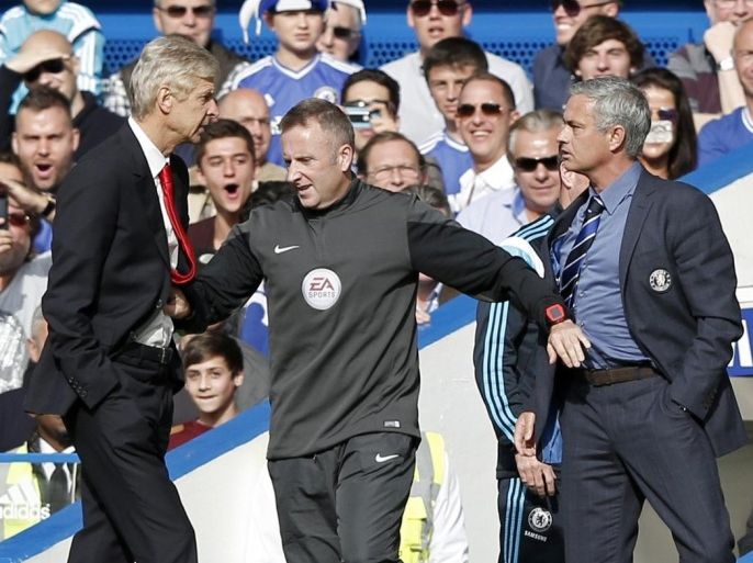 Chelsea's Portuguese manager Jose Mourinho (R) and Arsenal's French manager Arsene Wenger (L) are kept apart by the fourth official Jonathan Moss during the English Premier League football match between Chelsea and Arsenal at Stamford Bridge in London on October 5, 2014. AFP PHOTO/ADRIAN DENNIS == RESTRICTED TO EDITORIAL USE. NO USE WITH UNAUTHORIZED AUDIO, VIDEO, DATA, FIXTURE LISTS, CLUB/LEAGUE LOGOS OR 'LIVE' SERVICES. ONLINE IN-MATCH USE LIMITED TO 45 IMAGES, NO VIDEO EMULATION. NO USE IN BETTING, GAMES OR SINGLE CLUB/LEAGUE/PLAYER PUBLICATIONS. ==