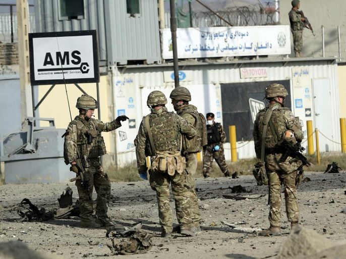 U.S. soldiers speak at the site of a suicide attack in Kabul, Afghanistan, Monday, Oct. 13, 2014. An Afghan official said a suicide bomber targeting a NATO convoy in Kabul has killed one civilian and wounded three others. (AP Photo/Massoud Hossaini)