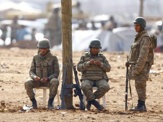 Turkish soldiers stand guard as Syrian Kurdish refugees wait behind the border fences to cross into Turkey near the southeastern town of Suruc in Sanliurfa province , October 17, 2014. A U.S. State Department official held direct talks for the first time last weekend with a Syrian Kurdish group involved in the fight against Islamic State in Syria, including the besieged town of Kobani, the State Department said on Thursday. REUTERS/Kai Pfaffenbach (TURKEY - Tags: MILITARY CONFLICT POLITICS)