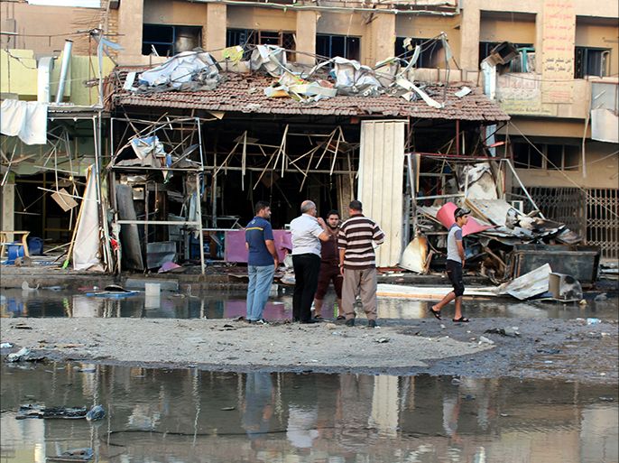 epa04426217 A group of Iraqis inspect the damage at the scene of a car bomb attack which ocurred late 30 September in the mainly Shiite district of Zafarana in the east of Baghdad, Iraq, 01 October 2014. According to local police reports at least nine people were killed and many more wounded in this attack which was part of a swathe of attacks across the Iraqi capital earlier 30 September and though responsibility has yet to be claimed militants from the organisation calling itself Islamic State (IS), who recently seized a large amount of territory across Syria and Iraq, have previously claimed responsibility for several suicide bomb attacks in the capital earlier in 2014. EPA/AHMED ALI