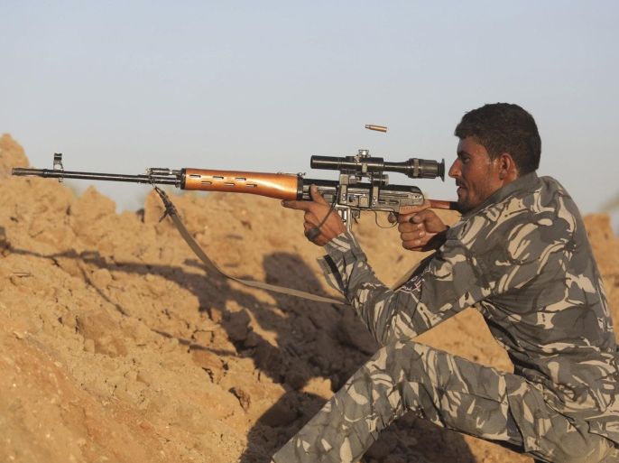 A Shi'ite fighter aims using a sniper rifle during a patrol in Jurf al-Sakhar October 25, 2014. Iraqi security forces made significant gains against Islamic State in a strategic area, Jurf al-Sakhar, near Baghdad on Saturday and Kurdish fighters retook a northern town after heavy coalition air strikes against the Sunni Islamist insurgents. Iraqi troops seized most of Jurf al-Sakhar, the biggest advance in months of battles against Islamic State in the town about 60 km (40 miles) south of Baghdad, senior local officials said. REUTERS/Stringer (IRAQ - Tags - Tags: CIVIL UNREST MILITARY)