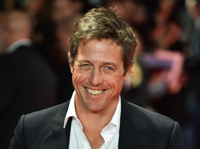 British actor Hugh Grant poses for pictures on the red carpet as he arrives to attend the European premier of his latest film 'The Rewrite' in London on October 7, 2014. AFP PHOTO/BEN STANSALL