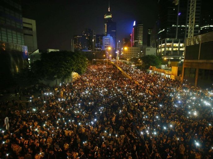 Protesters hold their mobile phones as they block the main street to the financial Central district, outside the government headquarters, in Hong Kong in this September 29, 2014 file photo. To match Special Report HONGKONG-CHINA REUTERS/Carlos Barria/Files (CHINA - Tags: POLITICS CIVIL UNREST)