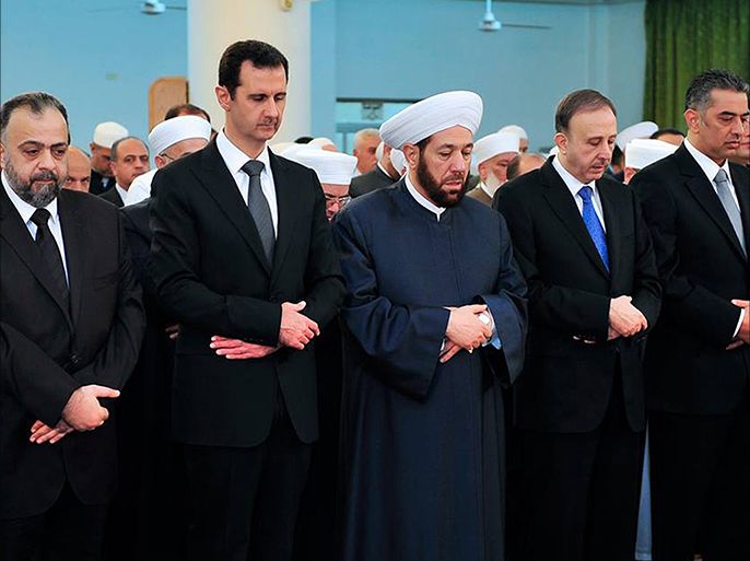 A handout picture released on the official Facebook page of the Syrian Presidency shows Syrian President Bashar al-Assad (2nd L) and Damascus's top cleric Adnan Afyouni (C), praying among other officials on the first day of Eid al-Adha at the Nuaman bin Bashir mosque in Damascus. Assad made a rare public appearance, attending the prayers on the Muslim Eid al-Adha holiday. AFP PHOTO / HO /THE OFFICIAL FACEBOOK PAGE OF THE SYRIAN PRESIDENCY == RESTRICTED TO EDITORIAL USE - MANDATORY CREDIT "AFP PHOTO / HO /THE OFFICIAL FACEBOOK PAGE OF THE SYRIAN PRESIDENCY" - NO MARKETING NO ADVERTISING CAMPAIGNS - DISTRIBUTED AS A SERVICE TO CLIENTS ==