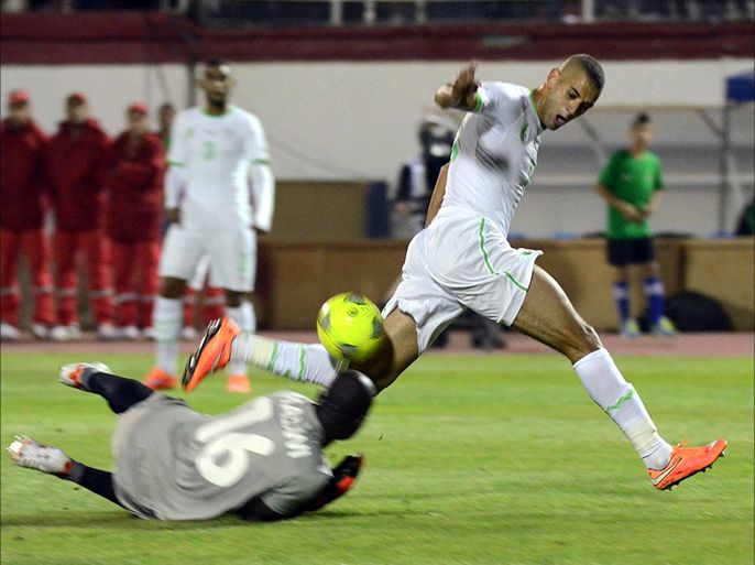 Algeria's Islam Slimani (R) vies with Malawi's goalkeeper during the 2015 Africa Cup of Nations qualifying football match between Algeria and Malawi at the Mustapha Tchaker stadium on October 15, 2014 in Blida. AFP PHOTO / STR