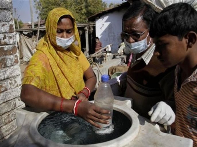 Indian health workers add disinfectants to a water storage tank at Kolat village near Ahmadabad, India, Wednesday, Jan. 19, 2011. An Ebola-like hemorrhagic fever has killed three people in western India and dozens of doctors will screen a community of about 16,000 people in efforts to contain the disease, a state health minister said Wednesday.