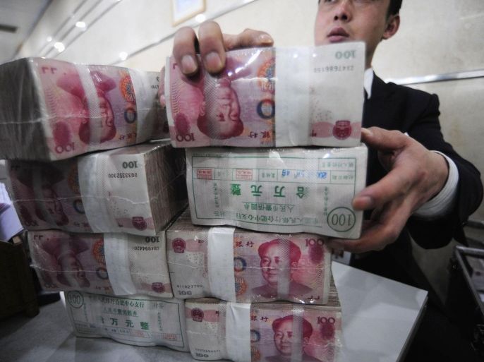 An employee packs bundles of Renminbi banknotes at a branch of the Bank of China in Hefei, Anhui province in this February 8, 2010 file photo. Companies gambling on yuan appreciation are distorting Chinese trade statistics, creating a monetary policy headache for Beijing officials and complicating government plans to liberalise the capital account. To match Analysis CHINA-EXPORTS/SPECULATION.