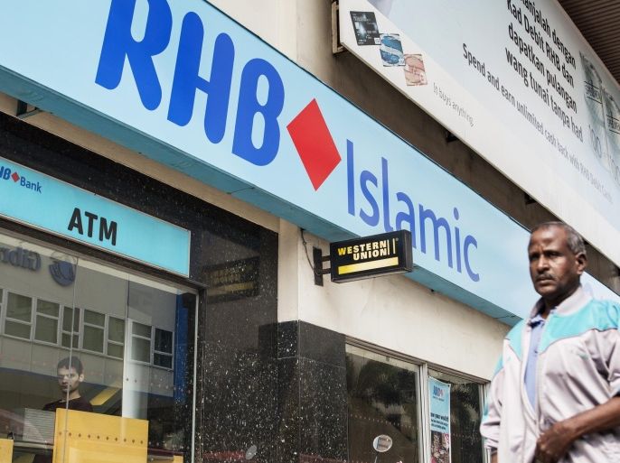 A pedestrian walks past an RHB Islamic Bank Bhd. branch in Kuala Lumpur, Malaysia, on Friday, Oct. 10, 2014. CIMB Group Holdings Bhd., Malaysia's second-biggest lender, and RHB Capital Bhd. agreed to a three-way merger with Malaysia Building Society Bhd. valued at 72.5 billion ringgit ($22.3 billion) that creates the nation's largest bank by assets.