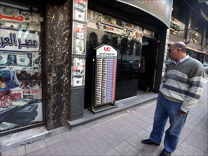 ‪مصري يطالع أسعار صرف العملات أمام محل للصرافة بالقاهرة‬ (الأوروبية-أرشيف)