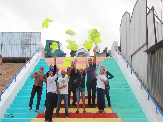 أعضاء من جمعية نظافة في سوق أهراس يحتفلون بإنهاء تنظيف وتلوين أحدى السلالم(الجزيرة)