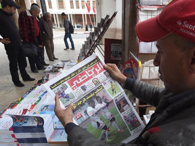 A Moroccan vendor reads the newspaper a day after it was announced Morocco would not hold the 2015 African Cup of Nations (CAN) on November 12, 2014 in Rabat. The stripping of Morocco hosting the Africa Cup of Nations, and being flung out of the competition after saying they wanted to postpone the tournament due to fears over the Ebola epidemic, and possible sanctions from the Confederation of African Football (CAF), made headlines in the Moroccan press. AFP PHOTO/ FADEL SENNA