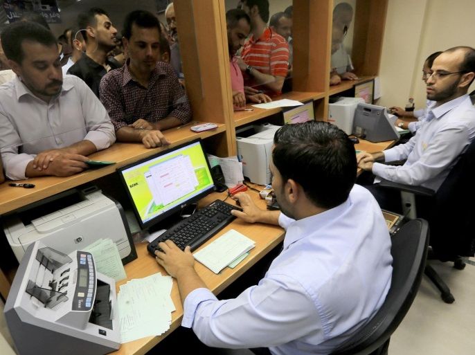 GAZA CITY, GAZA - SEPTEMBER 11: Palestinian employees receive their salaries that has been delayed for months due to insufficient funds in the Islamic National Bank on September 11, 2014 in Gaza City, Gaza. Months after the unity government established between Hamas and Fatah, the employees paid in Gaza City. (Mohammed Asad/Anadolu Agency/Getty Images)