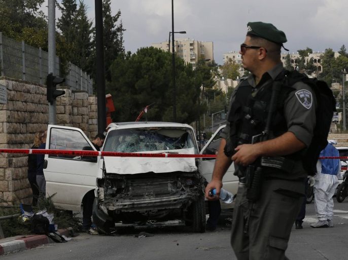 An Israeli border police officer walks in front of the vehicle of a Palestinian motorist who rammed into pedestrians, near the scene of an attack in Jerusalem November 5, 2014. The man rammed his car into pedestrians in central Jerusalem on Wednesday in the second attack of its kind in two weeks, killing one person and fueling concerns of another Palestinian uprising. REUTERS/Ammar Awad (JERUSALEM - Tags: POLITICS CIVIL UNREST)