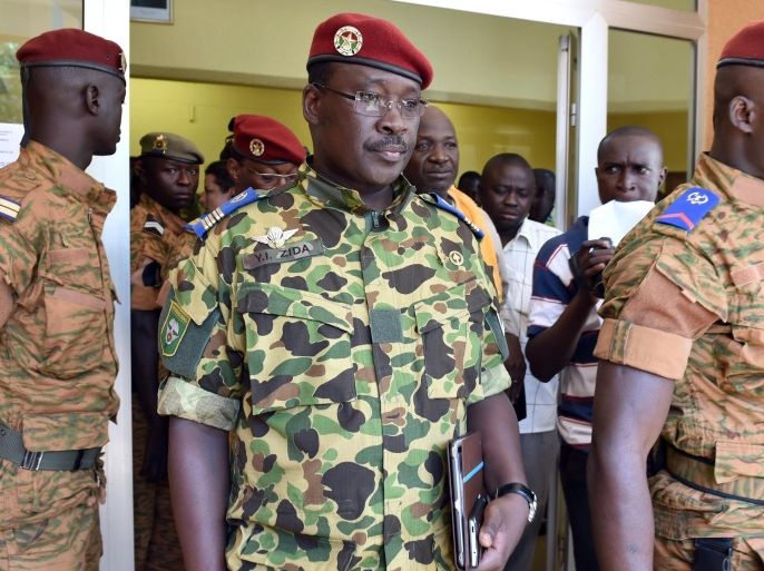 Burkina Faso's Lieutenant-Colonel Yacouba Isaac Zida (C) leaves after a meeting with the country's military commanders on November 1, 2014 at the military headquarters in Ouagadougou, during which the army backed him to lead a transition period after the ousting of the ex-president, according to a statement published after the meeting. Burkina Faso's army on October 31 backed a military officer's claim to lead the country's transition to democratic elections, as the ousted president Blaise Compoare took refuge in neighbouring Ivory Coast. Compaore resigned on October 30 after unrest over plans to extend his 27-year rule exploded into violence that saw parliament set ablaze, in protests closely watched across a continent where other veteran heads of state are also trying to cling to power. AFP PHOTO / ISSOUF SANOGO