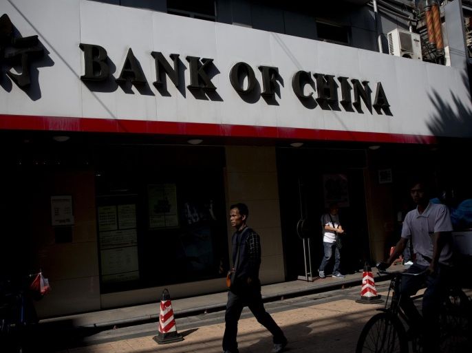 A pedestrian walks past a Bank of China Ltd. branch in the Gongbei district of Zhuhai, Guangdong province, China, on Sunday, Nov. 16, 2014. Investors piled into Shanghai shares on the first day of exchange-link trading, buying the maximum amount allowed in a sign of global demand for mainland equities as China opens up its $4.2 trillion market.