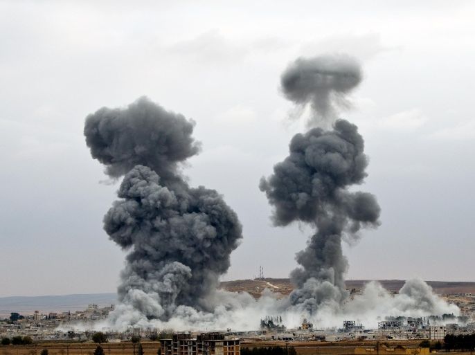 Smoke rises from the Syrian city of Kobani, following airstrikes by the US led coalition, seen from a hilltop outside Suruc, on the Turkey-Syria border Monday, Nov. 17, 2014. Kobani, also known as Ayn Arab, and its surrounding areas, has been under assault by extremists of the Islamic State group since mid-September and is being defended by Kurdish fighters. (AP Photo/Vadim Ghirda)