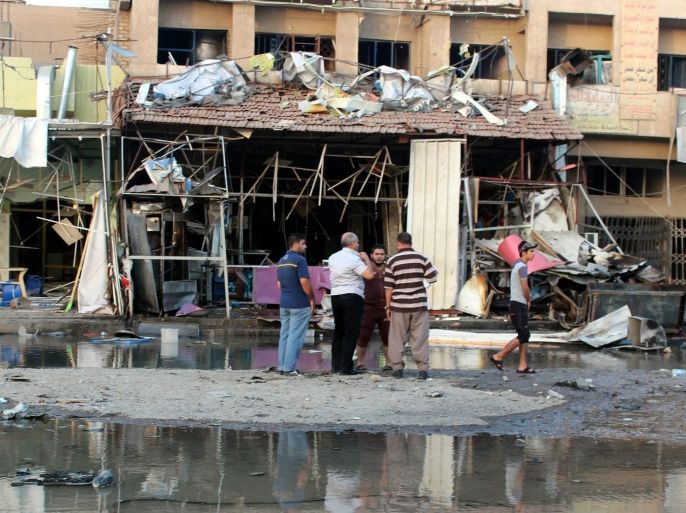 A group of Iraqis inspect the damage at the scene of a car bomb attack which ocurred late 30 September in the mainly Shiite district of Zafarana in the east of Baghdad, Iraq, 01 October 2014. According to local police reports at least nine people were killed and many more wounded in this attack which was part of a swathe of attacks across the Iraqi capital earlier 30 September and though responsibility has yet to be claimed militants from the organisation calling itself Islamic State (IS), who recently seized a large amount of territory across Syria and Iraq, have previously claimed responsibility for several suicide bomb attacks in the capital earlier in 2014.