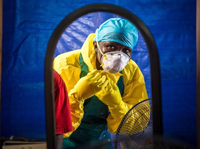 FILE - In this Thursday, Oct. 16, 2014 file photo, a healthcare worker dons protective gear before entering an Ebola treatment center in the west of Freetown, Sierra Leone. The government's worst-case scenario forecast for the Ebola epidemic in West Africa won't happen, a U.S. health official said Wednesday, Nov. 19, 2014. (AP Photo/Michael Duff, File)