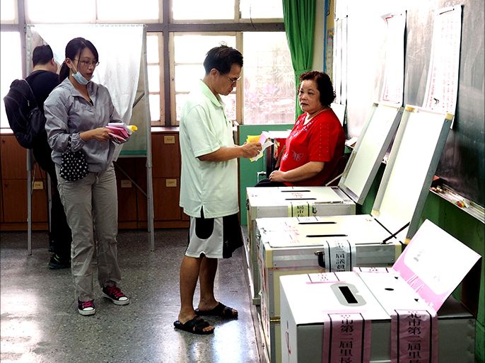 epa04507740 Voters cast their vote for local elections at a polling station in New Taipei City, Taiwan, 29 November 2014. Public opinion polls predict the opposition Democratic Progressive Party (DPP) could win over the China-friendly Chinese Nationalist Party (KMT) in the local elections, thus paving the way for DPP to return to power in the 2016 presidential election. EPA/DAVID CHANG
