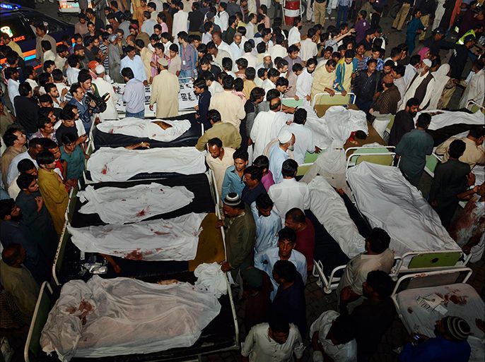Pakistani relatives gather around the bodies of blast victims after a suicide bomb attack near the Wagah border on November 2, 2014. A suicide bomber killed at least 45 people November 2 at the main Pakistan-India border crossing, the blast tearing through crowds of spectators leaving after the colourful daily ceremony to close the frontier. AFP PHOTO/ Arif ALI