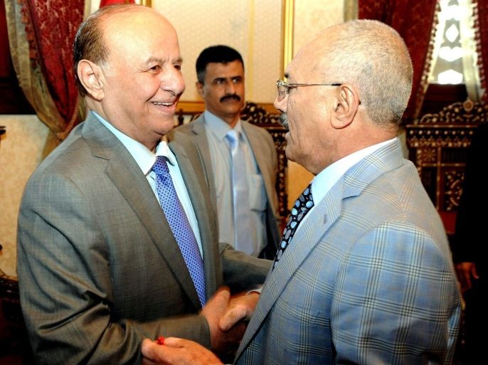 A handout photograph released by the Yemeni Presidency Office shows Yemeni President Abdo-Rabbo Mansour Hadi (L) welcoming his predecessor Ali Abdullah Saleh (R) after they performed Eid al-Fitr prayers at a mosque in Sanaa, Yemen, 28 July 2014. Around the world Muslims are celeberating the first day of the three day festival which marks the end of the Muslim holy month of Ramadan. EPA/YEMENI PRESIDENCY OFFICE / HANDOUT