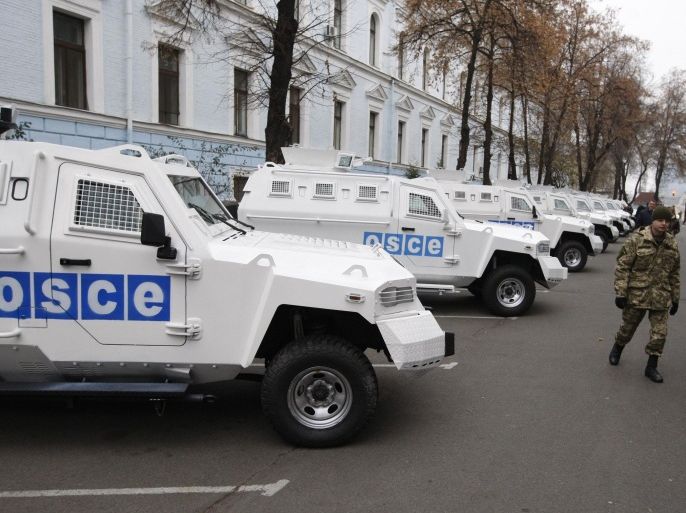 KIEV, UKRAINE - NOVEMBER 13: Ukrainian soldiers are seen near the armoured vehicles handed over to Organization for Security and Co-operation in Europe (OSCE) Special Monitoring Mission to Ukraine during the ceremony held at the Defense Ministry in Kiev, Ukranine, on November 13, 2014.