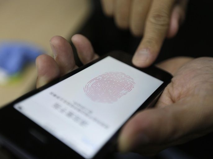 A journalist tests the the new iPhone 5S Touch ID fingerprint recognition feature at Apple Inc's announcement event in Beijing, September 11, 2013. Apple Inc's millions of Chinese fans will celebrate the near-simultaneous launch of the latest iPhone in China and the United States, but one group will have little to cheer - the smugglers. An early launch of Apple's latest smartphone in China is expected to stifle a thriving grey market worth billions of dollars a year built around smuggling from Hong Kong, where in the past the U.S. tech giant's gadgets have gone on sale months before they reach official channels in the mainland. REUTERS/Jason Lee (CHINA - Tags: MEDIA BUSINESS SCIENCE TECHNOLOGY)