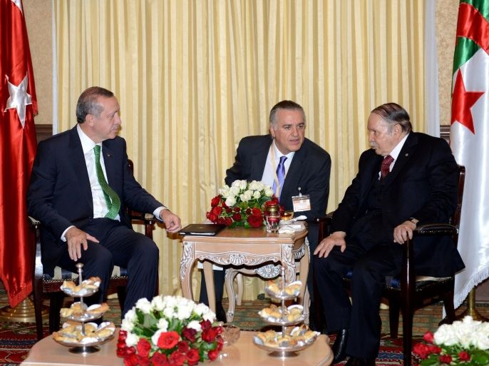 Turkish President Recep Tayyip Erdogan (L) meets with Algerian President Abdelaziz Bouteflika (R) following the former's arrival at Algiers airport, November 19, 2014, for an official visit to Algeria aimed at improving commercial ties. The trip is part of Ankara's efforts to shift its international focus to the Arab and Islamic world in light of the delay in its bid to join the European Union, the Algerian trade ministry said. AFP PHOTO / FAROUK BATICHE