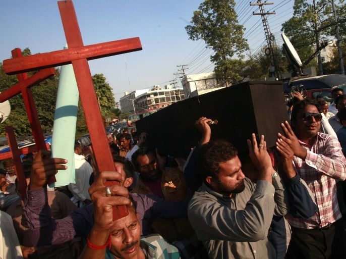 Members of the Pakistani Christian community carry wooden crosses and a casket during a demonstration to condemn the death of a Christian couple in a village in Punjab province on Tuesday, in Lahore November 5, 2014. Police in Pakistan arrested dozens of people on Wednesday after a mob beat a Christian couple to death and burned their bodies for allegedly desecrating a Koran. REUTERS/Mohsin Raza (PAKISTAN - Tags: RELIGION CIVIL UNREST CRIME LAW)