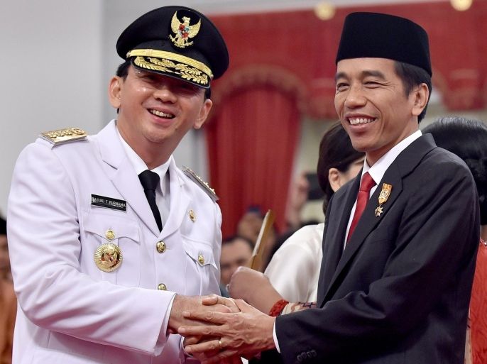 Indonesian President Joko Widodo (R) congratulates Jakarta's new governor Basuki Tjahaja Purnama (L), also known as Ahok, after he was sworn-in at the Palace in Jakarta on November 19, 2014. Widodo on November 19 inaugurated Ahok, the first ethnic Chinese to lead the capital of the world's most populated Muslim nation.AFP PHOTO / Bay ISMOYO