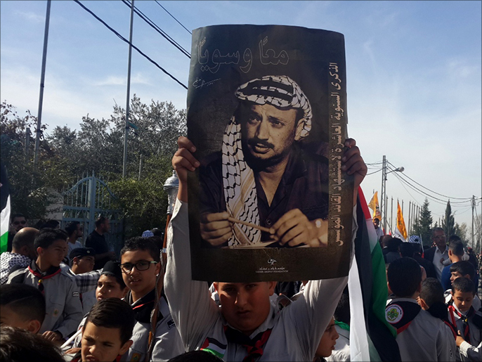 فتى فلسطيني يرفع صورة عرفاتفي ذكرى رحيله العاشرة (الجزيرة نت)