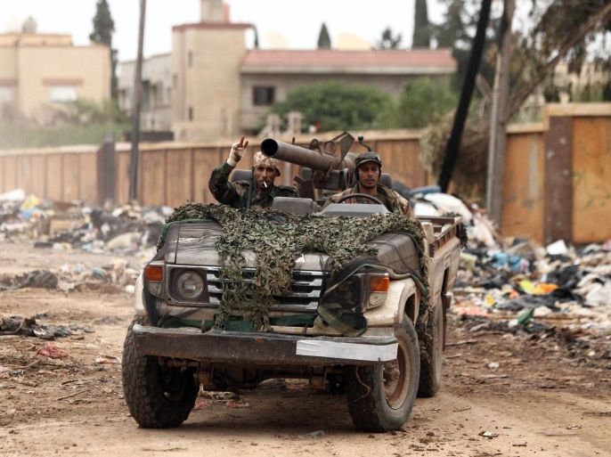 Troops loyal to Khalifa Haftar, a retired general and former chief of staff for Moamer Kadhafi, drive an armed vehicle as they fight alongside the Libyan army in clashes with Islamist gunmen in the eastern Libyan city of Benghazi on December 16, 2014. Battles between the coalition of the army and forces loyal to Haftar against militia gunmen took place in several parts of the city but the army reportedly secured the area south-west of the city centre. AFP PHOTO / ABDULLAH DOMA